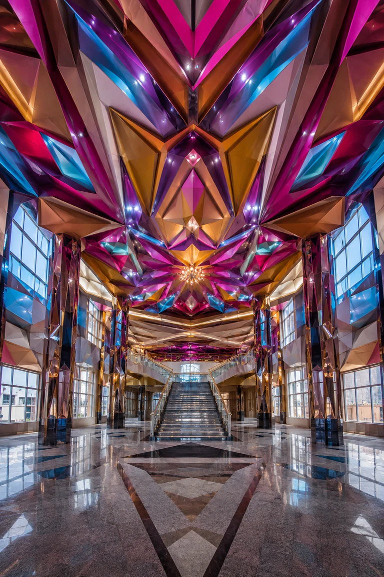 Photorealistic vertical Neo-Andean cholet event hall in El Alto with a soaring faceted ceiling, angular Andean geometry, magenta, cyan, gold, and violet light, mirrored columns, polished floor, symmetrical stair, and high-altitude daylight.